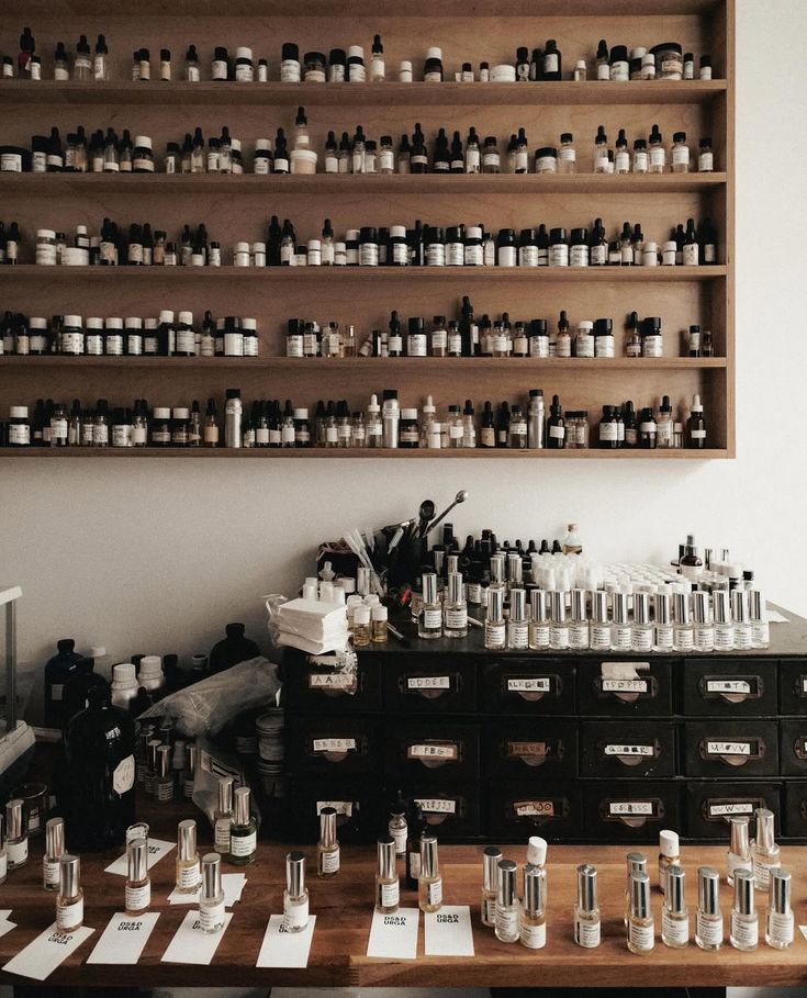Shelves of fragrance materials above a bench of finished bottles